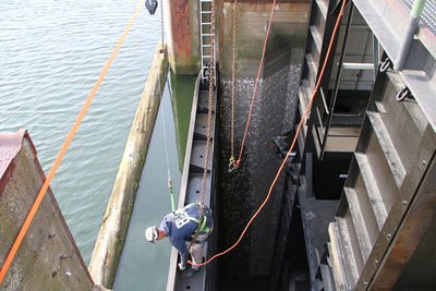 Ein NPorts-Mitarbeiter bringt die Kranhaken an einer der Dammtafeln an, die dafür gesorgt hat, dass während der Wartungsarbeiten kein Wasser in das Mitteltor läuft. 