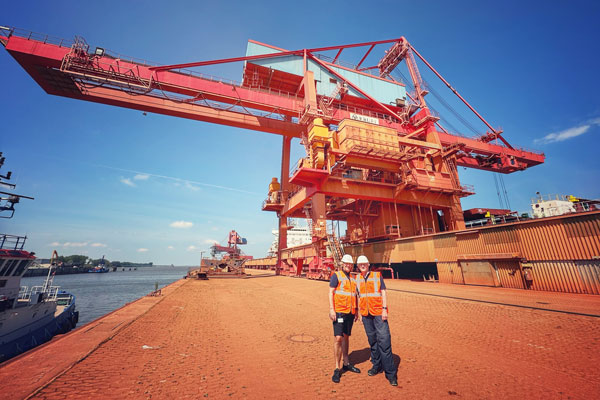 Wolfgang Holst und Jens Almer am Kai im Hafen Stade vor einem Ladekran für Schiffe