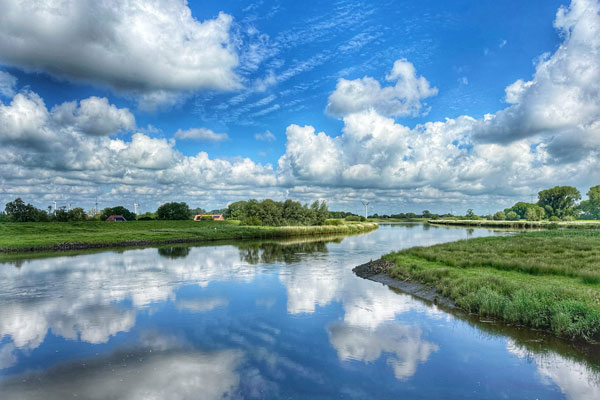 Landschaft mit Fluss bei sonnigem Wetter in der Gegend um Brake